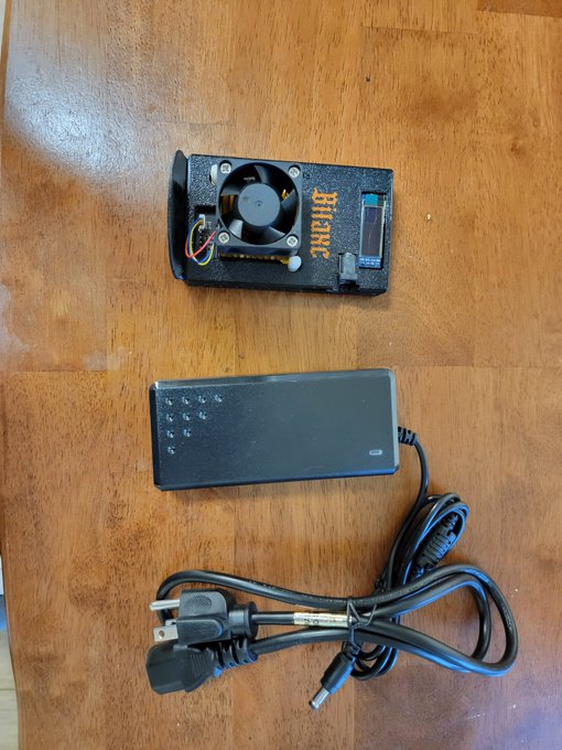 A Bitaxe Bitcoin solo mining device with its power supply unit and power cable, ready for setup. The "BITAXE" branding is visible on the device, which the poster received from SoloPoolBTC and BasicMining.