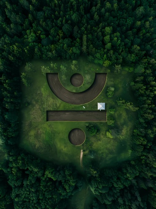 An aerial view of a geometric earthwork sculpture of a stylized face nestled within a dense forest clearing.

**Connection to the post:** The image's sculpture visually echoes the post's theme by using a stylized human face made of geometric shapes (a semicircle "smile," a rectangular "mouth," and circular "eyes") to represent how ENERGY functions as the operational "face" or vital resource behind every active DeFi action—much like facial features give expression and life, energy gives operational capacity to each swap, collateral adjustment, and staking transaction, transforming abstract technical detail into the visible identity of active blockchain engagement.