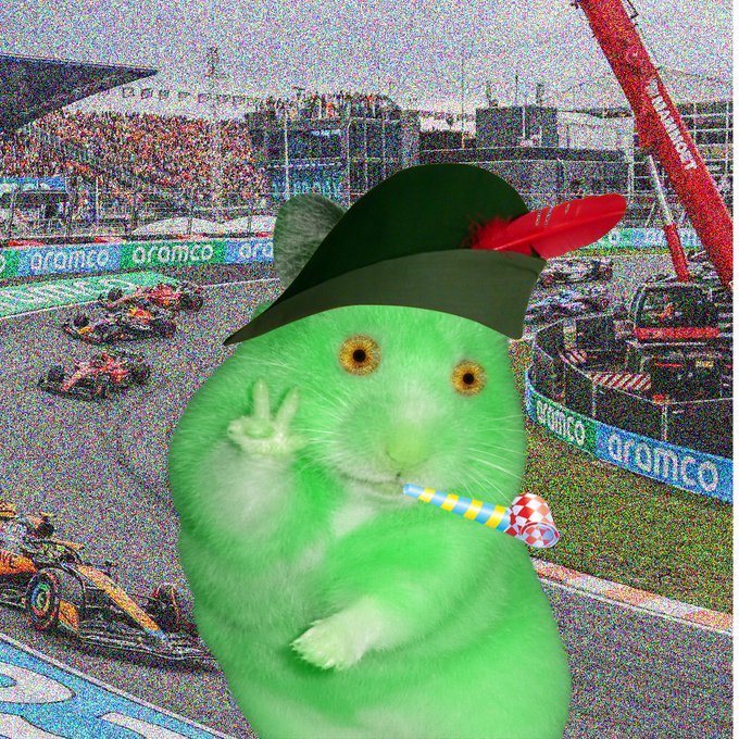 A green hamster wearing a pirate hat and blowing a party horn is superimposed over a noisy Formula 1 race scene with "aramco" branding visible on the trackside barriers. The image humorously combines the hamster mascot with a high-energy racing backdrop to promote a potential new Cash Hamsters NFT collection and collaboration for holders.
