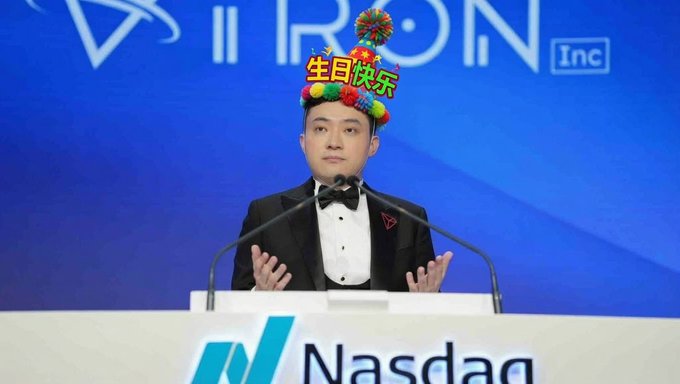A man wearing a black tuxedo and a colorful "生日快乐" (Happy Birthday) party hat stands at a Nasdaq podium, with the "TRON Inc" logo visible on the blue backdrop behind him.

The image captures a celebratory moment that aligns with the post's tribute, showing Justin Sun (孙哥) marking his 36th birthday at a Nasdaq event associated with TRON Inc, reflecting on his journey from Peking University and Ripple to founding TRON.