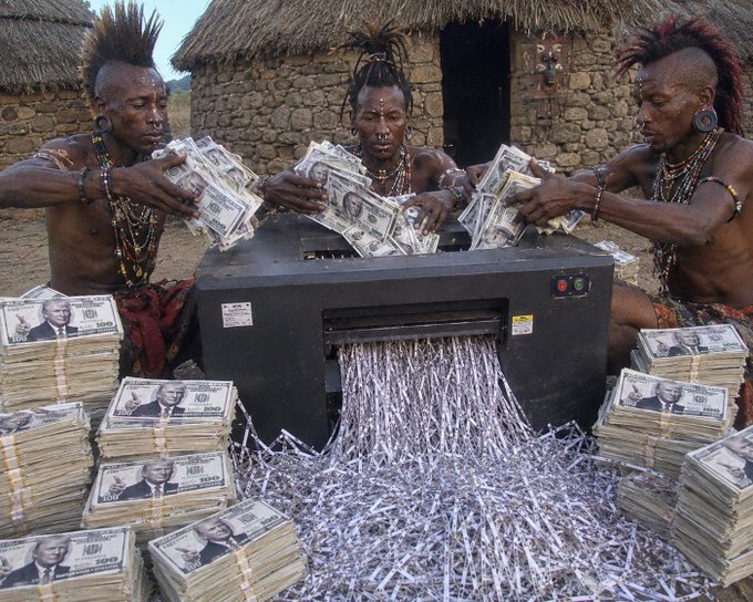 Three individuals with elaborate hairstyles and traditional beadwork feed stacks of $100 bills into a paper shredder, with shredded currency spilling out onto the ground amidst piles of cash in front of thatched huts, satirically illustrating the NFT artwork's theme "Nothing Personal Just Paperwork."