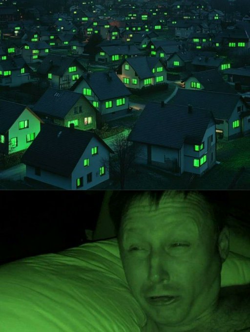 A split image showing houses with glowing green windows at night in the top half, and a man with a green-lit face lying in bed in the bottom half.