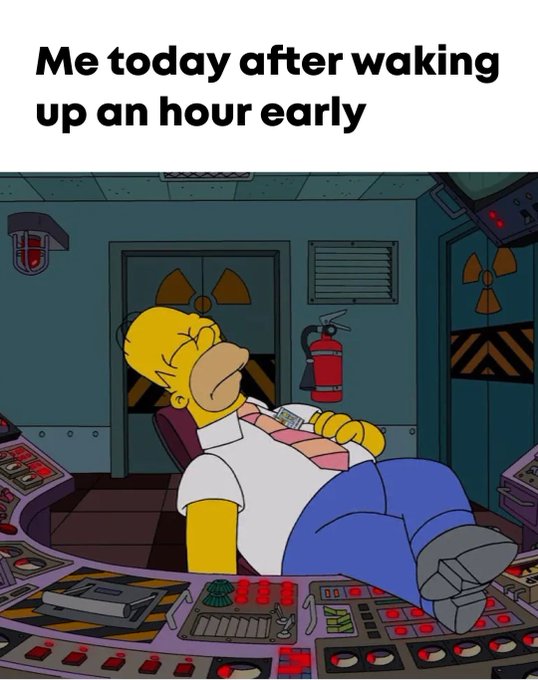 The image shows Homer Simpson passed out at his workstation at the Springfield Nuclear Power Plant control room, wearing a "Safety First" badge with his feet propped up. The caption at the top reads "Me today after waking up an hour early," humorously capturing the groggy, exhausted feeling many experience when daylight savings time forces an earlier wake-up call.