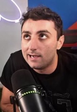 A man with dark hair speaks into a black studio microphone while looking off-camera, appearing to be recording a podcast episode.

The image relates to the accompanying post as it likely shows "Ras" or the podcast host making the quoted statements about the crypto token $PAID and its challenges in securing endorsements from prominent figures like Jason Calacanis and Elon Musk.