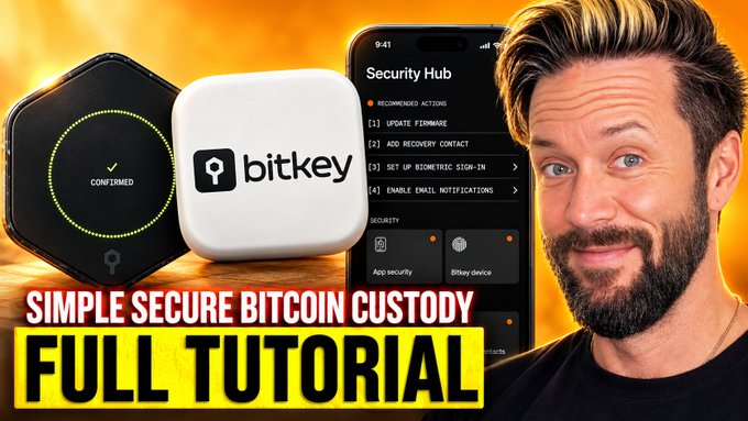 A YouTube thumbnail featuring a bearded man alongside images of a "bitkey" hardware wallet and a smartphone displaying a "Security Hub" interface with recommended actions like "UPDATE FIRMWARE," "ADD RECOVERY CONTACT," "SET UP BIOMETRIC SIGN-IN," and "ENABLE EMAIL NOTIFICATIONS," with bold yellow text reading "SIMPLE SECURE BITCOIN CUSTODY FULL TUTORIAL."

The image promotes a video tutorial reviewing Bitkey's security features by stress-testing it against disaster scenarios like losing both a phone and hardware wallet, highlighting the app's recovery and security setup options shown on screen.