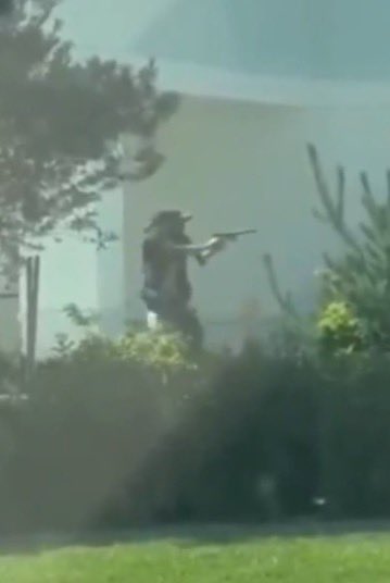 A silhouetted figure stands amid foliage, aiming a rifle forward, evoking imagery of armed confrontation that aligns with the post's nostalgic reference to a violent, stylized aesthetic associated with the film "Scarface."