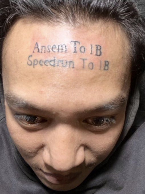 A close-up photo shows a man's forehead tattooed with "Ansem To 1B" and "Speedrun To 1B," referencing the viral Ansem crypto airdrop joke from the post about permanently inking the meme on his forehead.