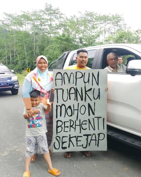 The image shows a group of people standing next to a white car with a sign written in another language attached to its side, which reads "Ampu tun Kuon mohon berhenti sekejap". The group consists of a man, woman, and child. They are all posing for the photo while holding onto the sign. The post also includes text that says: "If it were up to our folks, they'd have already tied the knot by now, and that wouldn'nt have been enough—they'd have already started mining BTC too." This message seems to be a reference to Bitcoin or cryptocurrency, possibly indicating an interest in this digital currency.