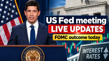 A news broadcast screenshot showing a man at a podium with the text 'US Fed meeting LIVE UPDATES' and 'FOMC outcome today' alongside 'INTEREST RATES' graphics.