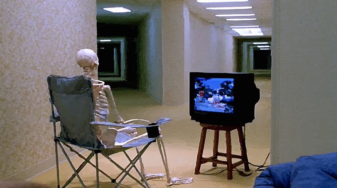 A surreal 3D rendering of a skeleton sitting in a folding camping chair, watching television on a small TV set atop a stool in a long, repetitive hallway.