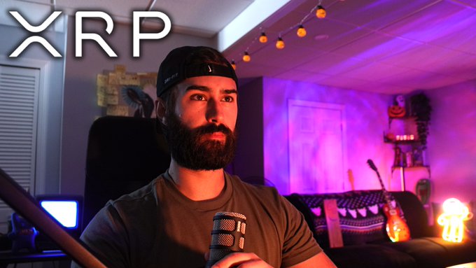 A bearded man wearing a black cap sits in a purple-lit room speaking into a microphone, with the text "XRP" displayed in the upper left corner, aligning with the post's reference to a live YouTube stream about XRP and crypto news.