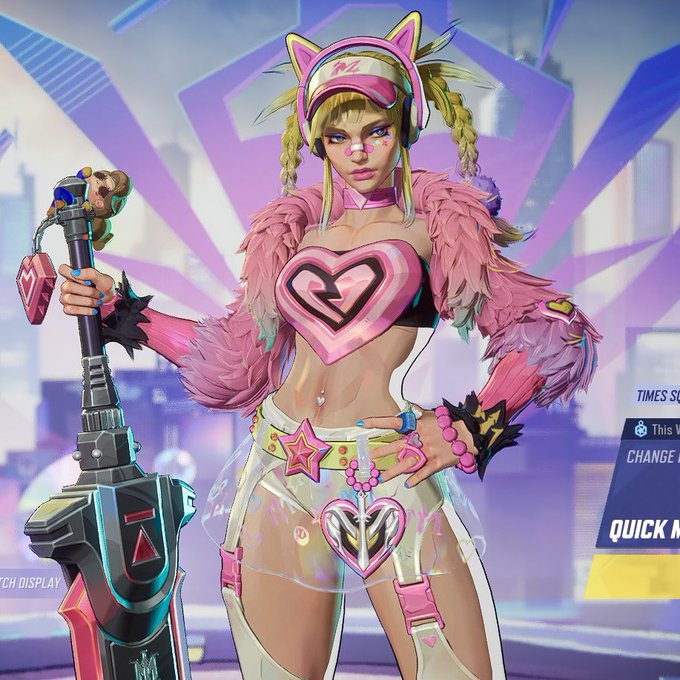 Stylized anime-style character with blonde braids, cat-ear headgear, a pink heart-shaped top, fluffy pink jacket, and a clear skirt, holding a large futuristic weapon.