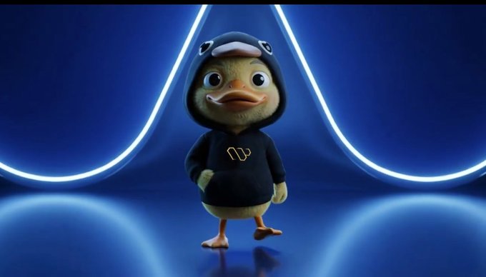 The image features a cartoon duck wearing a black hoodie with a yellow logo standing against a blue background. The duck appears to be posing for the camera, giving off an engaging and lively vibe. The caption below the image reads "Good afternoon legend @wallchain keeps standing out with its focus on rewarding real participation. Instead of chasing noise, the system leans toward consistency, meaningful engagement, and actual contribution". This message seems to be related to the cartoon duck's character or theme in some way, possibly as a reference to the duck's role within the image or the overall concept behind it.