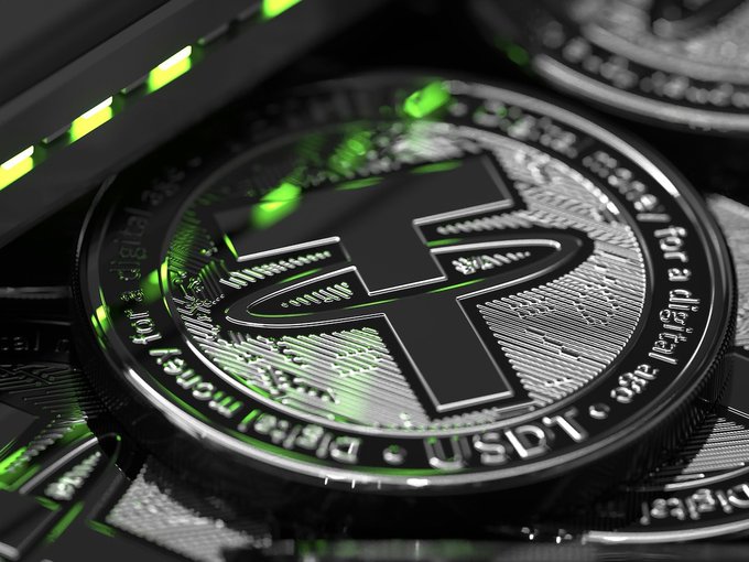 A close-up of Tether (USDT) cryptocurrency coins is shown, with the prominent "₮" symbol and "Digital money for a digital age" text visible. The image complements the post by highlighting USDT's significant role in commerce payments, as referenced in the article's discussion of stablecoin use cases.