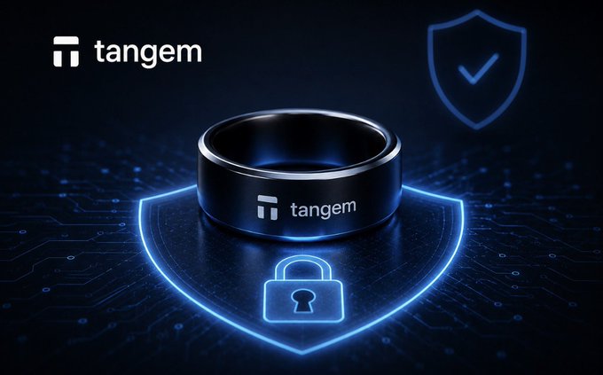 A black 'tangem' smart ring displayed on a blue glowing shield with a padlock icon, emphasizing security on a dark digital background.