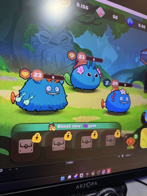 The image shows a computer monitor displaying an animated video game scene with three cartoon characters, two blue and one green, standing on a grassy field. The characters are facing each other, possibly engaged in a conversation or preparing for an adventure. A keyboard is visible near the bottom of the screen, suggesting that the viewer might be playing the game using a computer mouse as well. The post about web3 gaming has been shared by someone who seems to enjoy this particular video game and its characters.