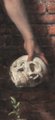 A dim, dark image showing what appears to be a white skull or round object being held or manipulated by a hand against a dark background.