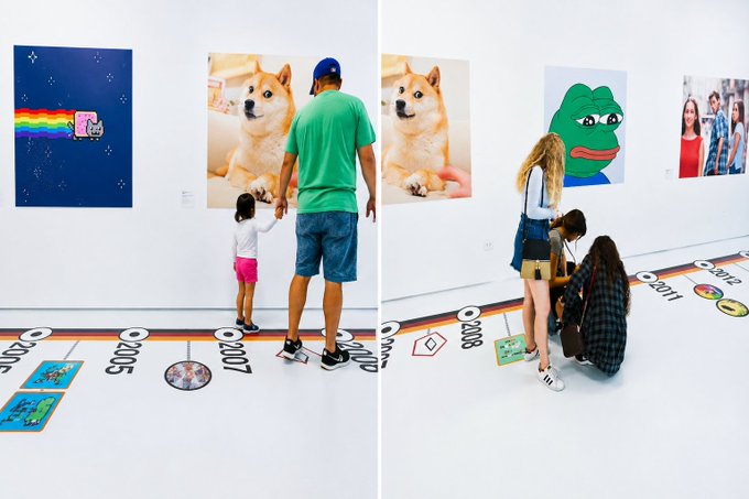 Visitors view NFT artworks including a Nyan Cat piece, a Shiba Inu (Doge) portrait, and a Pepe the Frog painting in a gallery, with a timeline featured on the floor showing years from 2005 to 2012.