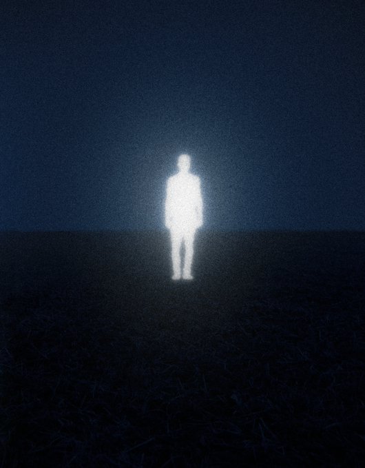 A glowing white silhouette of a standing human figure in a dark, empty field at night, creating an eerie and surreal atmosphere.