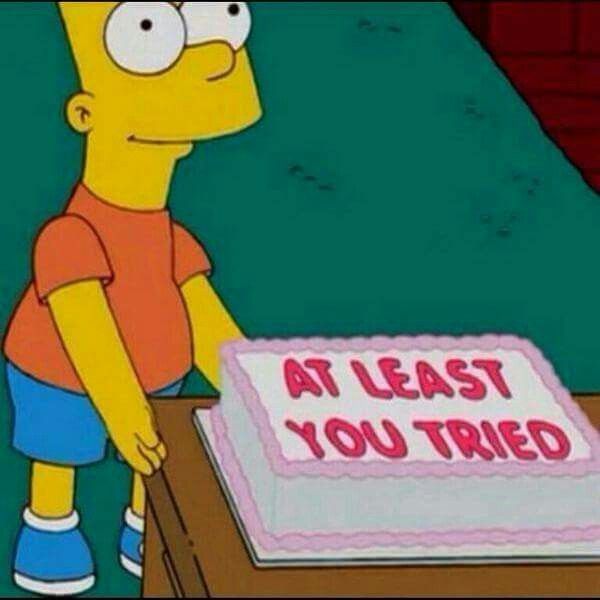 An image from the animated TV show The Simpsons showing Bart Simpson standing next to a white cake with pink trim that reads 'AT LEAST YOU TRIED' in red icing.