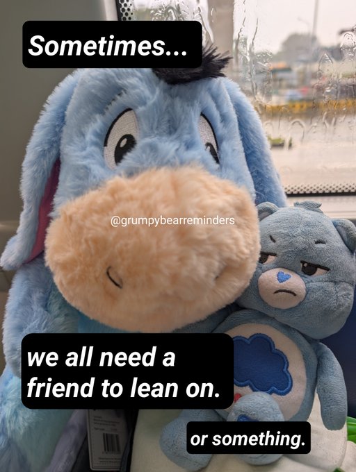 A photo of a blue Eeyore plush toy hugging a smaller grumpy teddy bear, with text reading 'Sometimes... we all need a friend to lean on. or something.' and the handle @grumpybearreminders.