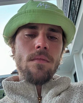 A selfie of a bearded man wearing a light green bucket hat with 'MP' written on it and a cream fleece jacket.