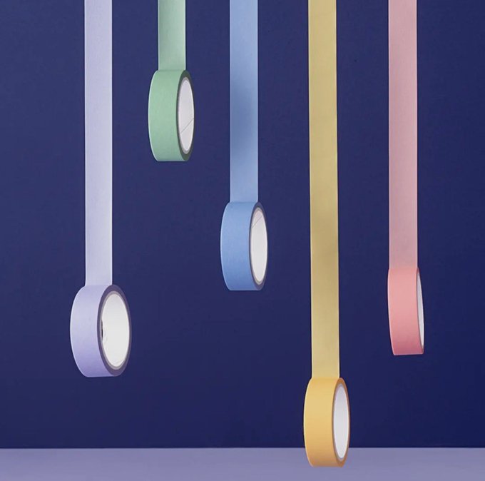 Five colorful pendant-style hanging lights in purple, green, blue, yellow, and pink suspended against a dark blue background.