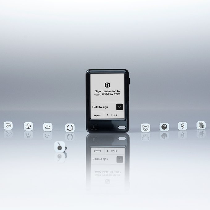 A black hardware wallet displays the confirmation prompt "Sign transaction to swap USDT to BTC?" with "Hold to sign" and "Reject" options, set against a clean reflective surface. The sleek device is surrounded by row of icons representing various crypto tickers, visually reinforcing the post's message that a Ledger signer provides a secure, tamper-proof alternative to trusting third-party exchange announcements when verifying token transactions.