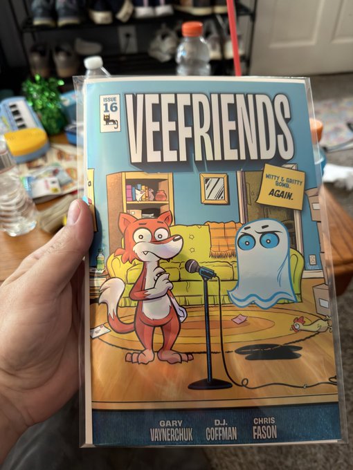 A hand holds up Issue 16 of the "VEEFRIENDS" comic book, featuring characters Gary Vaynerchuk, D.J. Goffman, and Chris Fason on the cover, celebrating the Veefriends birthday.
