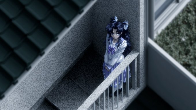 An anime figure of a girl with blue twin-tails and a white and blue outfit stands on a balcony of a miniature model house.
