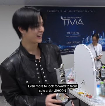 A K-pop artist identified as 'JIHOON' from 'TMA - IN BUSAN' speaks backstage, with subtitles reading 'Even more to look forward to from solo artist JIHOON'.