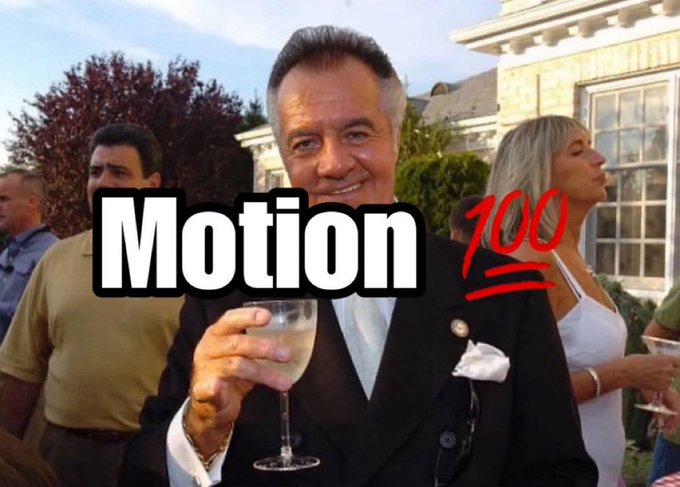 The image shows a man smiling and holding a wine glass at what appears to be an outdoor social gathering, with the text "Motion 100" overlaid in white and red lettering. The overlay reinforces the post's reference to "$MOTION," humorously presenting the ticker as if it's achieved a perfect "100" score.