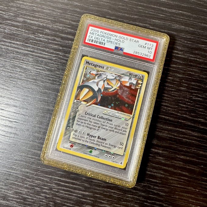A PSA-graded Gem Mint 10 Pokemon card, specifically the 2005 Metagross Gold Star Holo from the Delta Species set (#113), displayed in a protective case on a dark wooden surface.