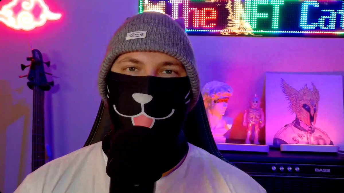 The image features a man wearing a black face mask with a cat design, possibly for protection or as part of an art project. The caption includes questions about NFTs and their impact on users' experiences.