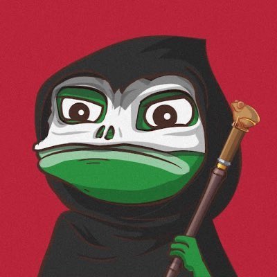 The image features a cartoon frog with a green face, wearing a black hooded robe or cape that covers its entire body. It has a stick in one hand and a gold-colored object in the other. The background of the image is red, which contrasts with the frog's green face and adds to the overall visual impact of the scene.