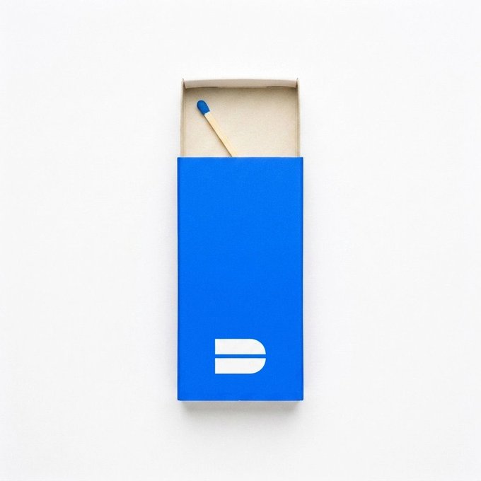 A minimalist image of an open blue matchbox with the letter 'D' logo, containing a single wooden match with a blue tip.