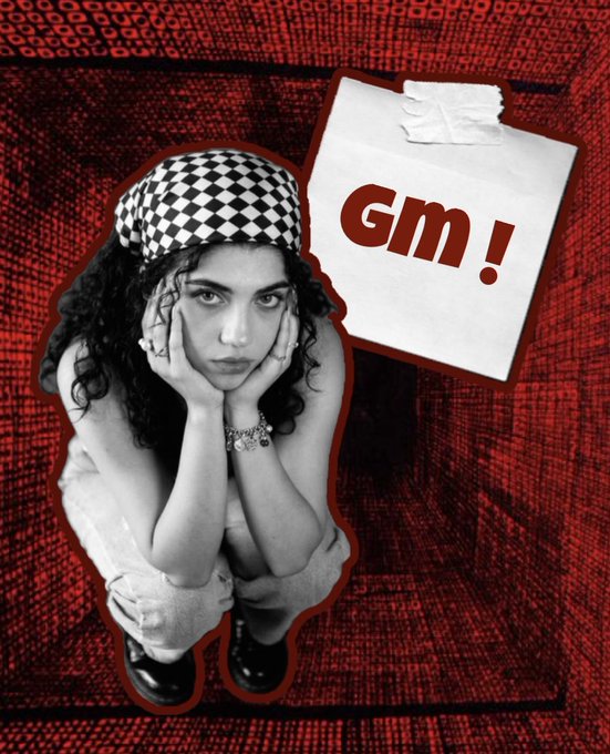 A stylized photo collage features a black-and-white image of a person wearing a checkered bandana crouching with hands on their face, placed on a red textured background next to a taped note reading 'Gm!'.