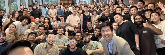 A large group of smiling team members gathers closely together for a celebratory team photo, with several people giving thumbs-up gestures and a man in a gray blazer standing prominently in the front. The image complements the post by capturing the camaraderie at Jupiter Exchange as the author concludes their tenure working on the developer platform.