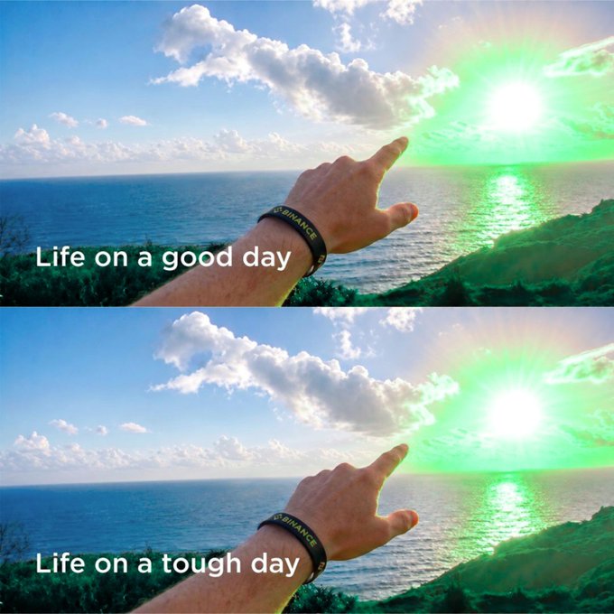 A two-panel meme showing a hand pointing at a sunset with a green flash over the ocean; the top reads 'Life on a good day' and the bottom reads 'Life on a tough day', with a 'BINANCE' wristband visible.