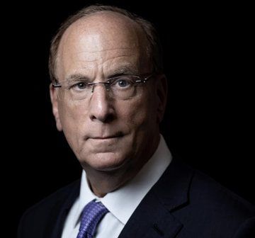 A professional headshot of a serious-looking older man with short hair, glasses, and a dark suit with a purple tie, photographed against a black background—likely Larry Fink, CEO of BlackRock, whose $15 trillion asset management firm is featured in the accompanying post highlighting BlackRock's bullish stance on Bitcoin as a portfolio diversifier and emerging global monetary alternative.