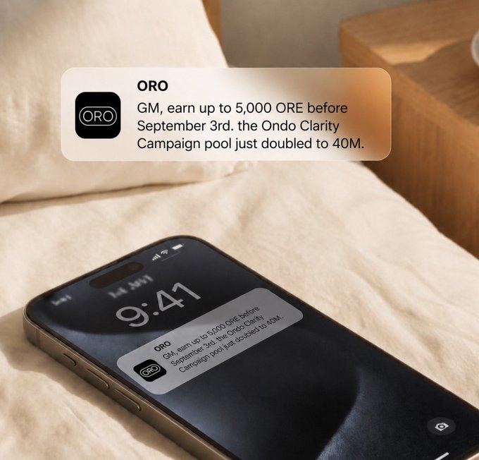 A smartphone rests on a bed displaying a notification from "ORO" that reads: "GM, earn up to 5,000 ORE before September 3rd. the Ondo Clarity Campaign pool just doubled to 40M." The image visually promotes the accompanying message about ORO's 40M token reward pool and upcoming September 3rd deadline via the app.askoro.ai platform.