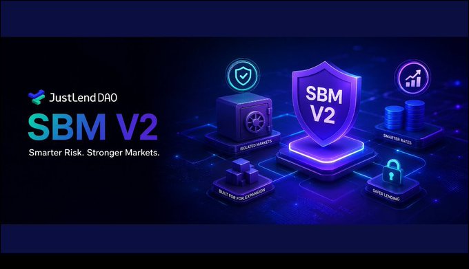 A promotional graphic for "JustLendDAO SBM V2 - Smarter Risk. Stronger Markets." featuring shield and chart icons on a blue digital background.