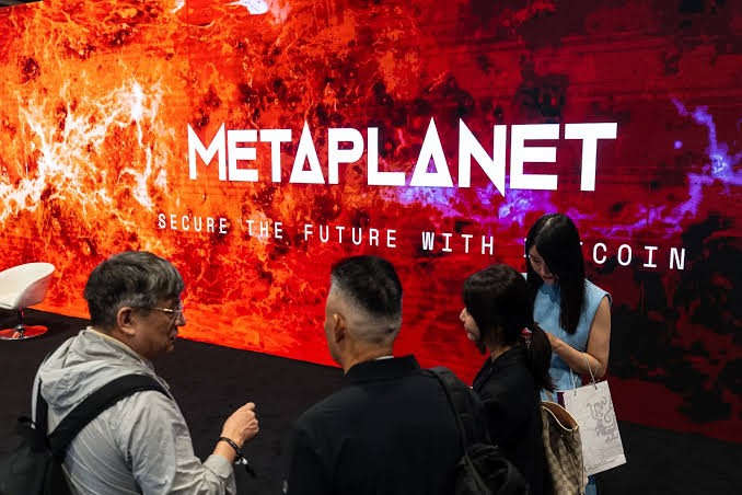Attendees gather in front of a Metaplanet booth displaying the "Secure the Future with Bitcoin" tagline, evoking the company's aggressive Bitcoin acquisition strategy highlighted by its 2,823 BTC purchase in Q2.