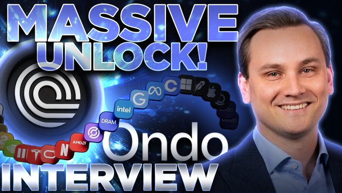 The image features a man wearing a suit, smiling for the camera during an interview. He appears to be a businessman or a professional. The background of the image has a blue color with white text that reads "Massive Unlock! @paulbarron & @iandebode now live". This suggests that the image is part of a promotional campaign or advertisement related to a product, service, or event.