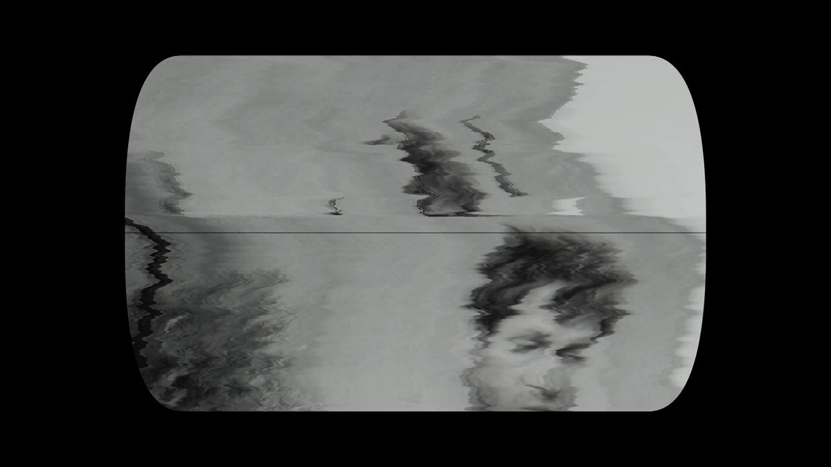 The image is a black and white photograph of a person's face, possibly someone with short hair and dark eyes. The background appears to be a wall or a table surface. There are some words written on this picture that seem unrelated to the main subject matter but provide context about the photo.