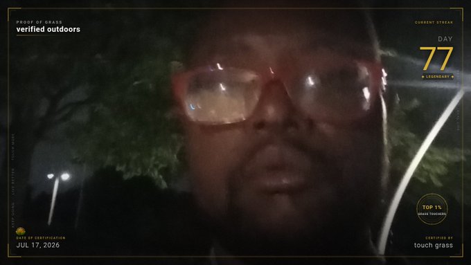 A man wearing red-framed glasses speaks to the camera in a dark outdoor setting, framed by an overlay graphic showing "verified outdoors," "Day 77," "Top 1%," and "certified by touch grass" dated "Jul 17, 2026." The overlay's playful branding aligns with the post's confident, motivational tone, reinforcing the "verified outdoors" and "touch grass" themes of genuine real-world engagement.