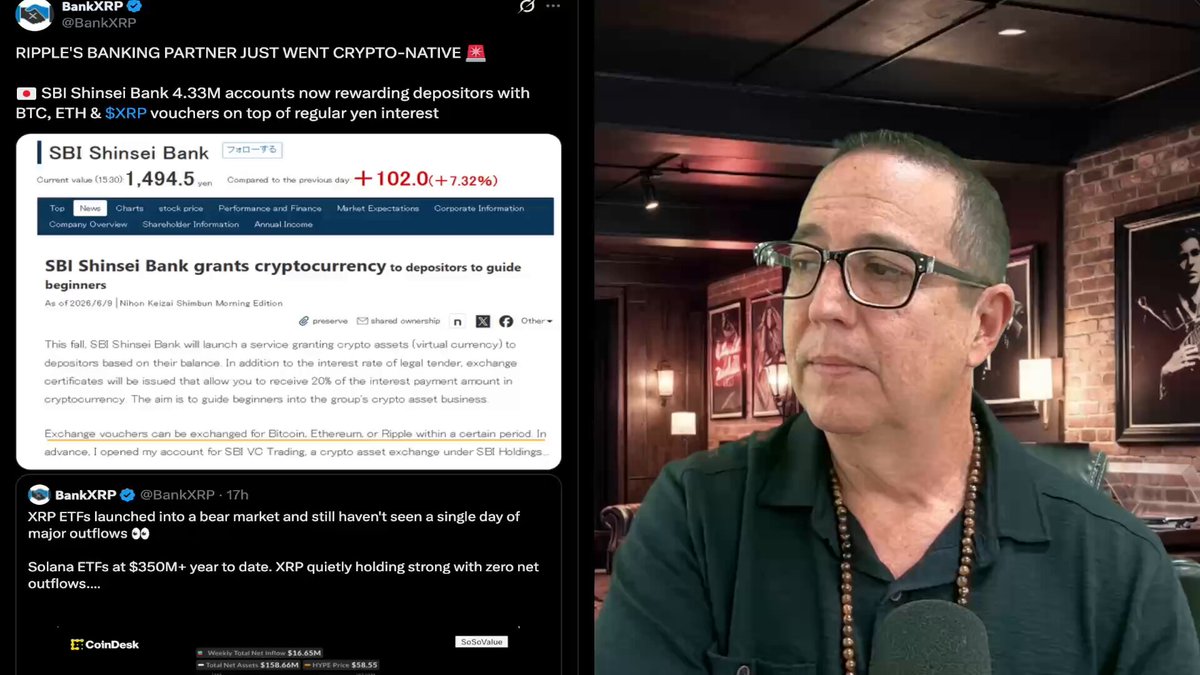 The image shows a man wearing glasses sitting at a table in front of a computer screen, likely working or browsing. The screen displays a financial news website showing a Bitcoin update that includes information about crypto exchanges like RippleBank and altcoin mining. One quote is visible on the screen with a URL: "SBI Open XRP Up To 4.33M Acounts youtu.be/P2zk8Xg3-q4". The man appears to be focused on the content displayed, possibly discussing or researching the crypto market and its updates.