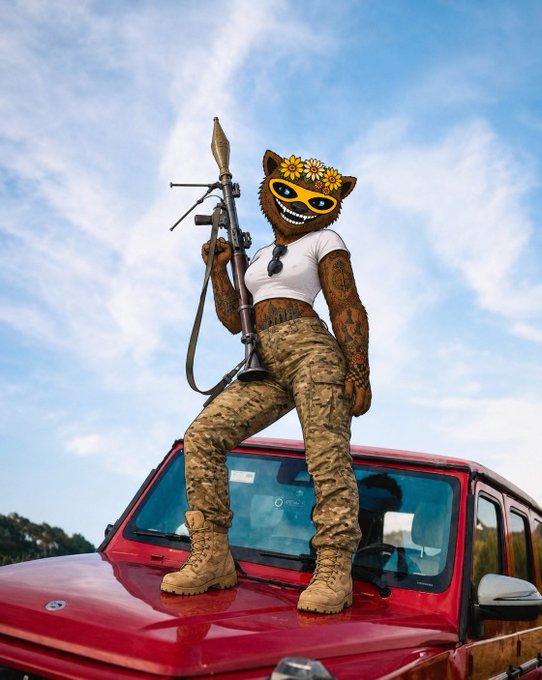 An anthropomorphic brown wolf character wearing military camouflage pants and boots, holding an RPG launcher while standing on the hood of a red vehicle.