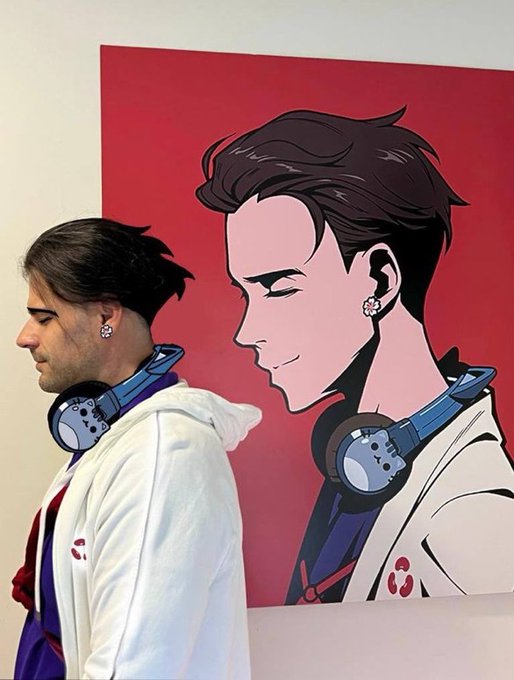A person wearing a white hoodie and headphones posing next to an anime-style portrait illustration of a character with similar features, both featuring diamond earrings.