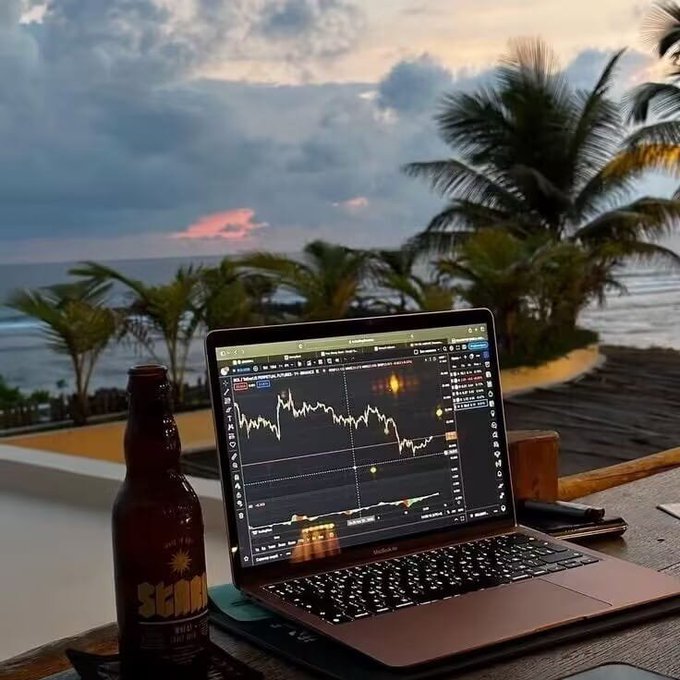 A laptop showing trading charts sits on a table beside a beer bottle labeled "SOL" overlooking a tropical beach at sunset, capturing the ironic contrast between seeking a relaxing paradise while still tethered to the stressful world of crypto trading. The post's theme about simplifying trading strategies and learning from past mistakes of overcomplicating approaches resonates with the scene's depiction of someone trying to escape into a serene environment while monitoring volatile MACD charts.
